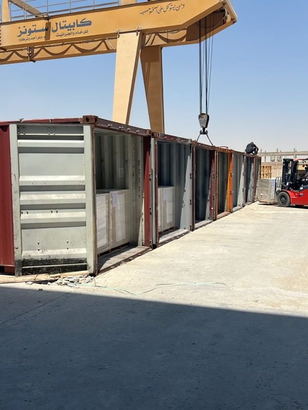 Loading natural marble slabs into shipping containers for export, using a forklift at an outdoor storage site